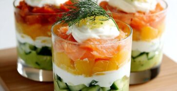 Verrines d’avocat crémeux, yaourt grec onctueux et saumon citronné, garnies d’aneth frais et de dés de concombre.