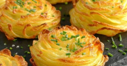 Nids de pommes de terre dorés et croustillants au four, dressés sur une plaque avec ciboulette ciselée, texture légère et aérée, prêts à être dégustés