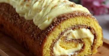 Bûche roulée garnie de crème de marrons et crème chocolat blanc, décorée de noix de coco et framboises, montrant une spirale régulière à la découpe