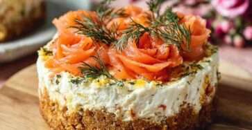 Mini cheesecake salés garnis de saumon fumé roulé en rosaces et d’aneth frais, présentés en petites portions individuelles sur une assiette