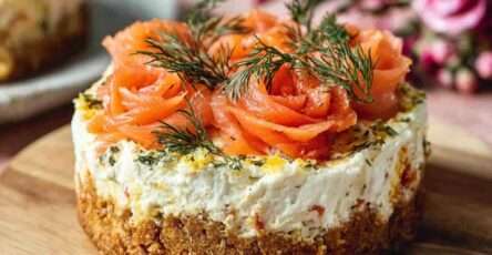 Mini cheesecake salés garnis de saumon fumé roulé en rosaces et d’aneth frais, présentés en petites portions individuelles sur une assiette