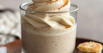 Verrine mousse transparente remplie de mousse au café onctueuse pochée à la douille, décorée de cacao en poudre avec biscuit émietté au fond