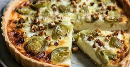 Quiche dorée aux poireaux rôtis, comté fondu et noisettes concassées, servie en parts avec une garniture fondante et un dessus légèrement gratiné