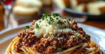 Spaghetti bolognaise maison avec sauce tomate mijotée au bœuf, légumes fondants, parmesan râpé et persil frais, servis dans une assiette creuse.