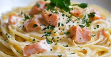 Assiette de spaghetti au saumon nappés de sauce crémeuse avec herbes fraîches et citron