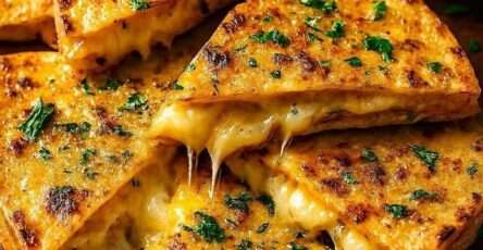 Quesadillas dorées au beurre à l’ail avec fromage mozzarella et cheddar fondant, coupées en triangles et garnies de persil frais, servies avec sauce tomate.