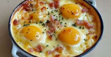 Œufs cocotte au fromage et lardons servis en ramequins, blancs pris et jaunes coulants, accompagnés de pain grillé.