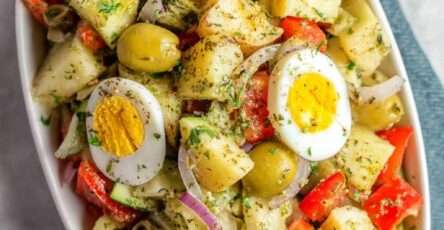 Salade italienne de pommes de terre avec œufs durs, tomates, courgettes, olives vertes et herbes fraîches, assaisonnée à l’huile d’olive. Insalata di Patate