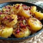 Poêlée de pommes de terre dorées avec lardons fumés croustillants et oignons fondants, servie chaude dans une poêle rustique.