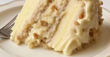 Gâteau à étages aux amandes recouvert d’un glaçage crémeux à la noix de coco et aux noix de pécan, texture fondante et finition gourmande