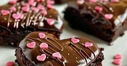 Cœurs de brownies au chocolat glacés avec nappage brillant, décorations en forme de cœur, texture fondante et présentation élégante pour la Saint-Valentin.