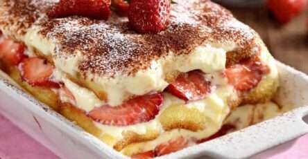 Tiramisu aux fraises en couches avec crème mascarpone onctueuse, biscuits imbibés et fraises fraîches, dessert servi bien frais.
