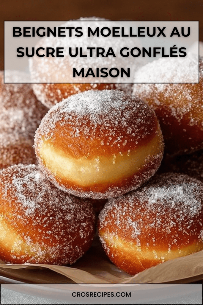 Beignets moelleux au sucre dorés et gonflés, texture aérée visible à la découpe, enrobés de sucre et servis chauds sur une assiette
