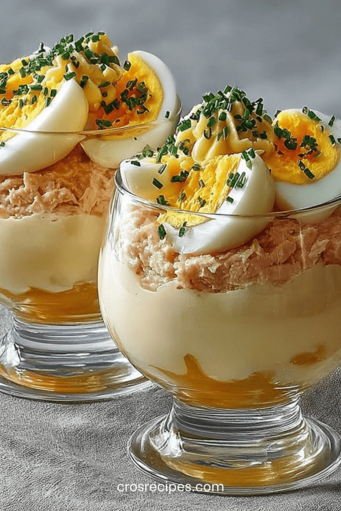 Verrines thon et œufs mimosa en couches, garnies de ciboulette fraîche et pointe de mayonnaise crémeuse.