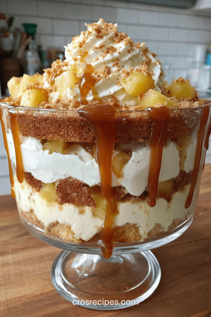 Verrine pommes transparente garnie de couches de gâteau moelleux, crème légère au fromage frais, pommes caramélisées fondantes et nappage caramel coulant.