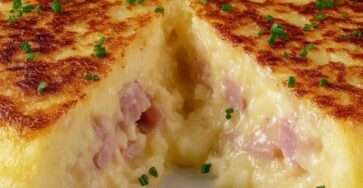 Tourte aux pommes de terre dorée à la poêle, garnie de fromage fondant et de jambon, servie chaude sur une assiette rustique avec texture crémeuse visible