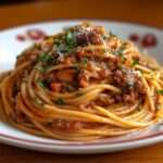 Spaghetti bolognaise maison avec sauce tomate épaisse au bœuf haché, légumes fondants, persil frais et parmesan râpé servis dans une assiette creuse