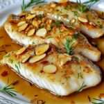Filet de poisson doré à la poêle, nappé de beurre citronné aux amandes effilées, servi avec herbes fraîches et sauce brillante