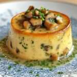 Flan salé individuel aux champignons de Paris et ciboulette, texture fondante, démoulé sur assiette avec finition aux herbes fraîches