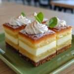 Carrés citron et crème vanille, base biscuitée, couches fondantes et finition au sucre glace, découpés en parts nettes.