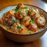 Mijoté de poulet crémeux aux champignons et pommes de terre, sauce onctueuse, servi bien chaud en cocotte.