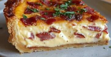 Quiche aux lardons et fromage dorée au four, texture fondante à l’intérieur, servie en parts avec herbes fraîches.