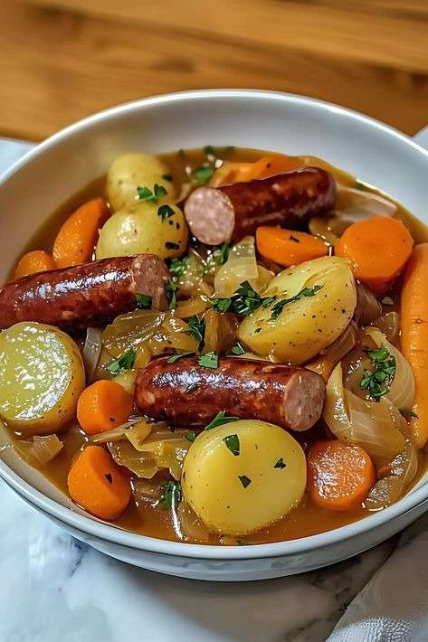 Potée aux saucisses fumées servie en cocotte avec pommes de terre, carottes et chou vert mijotés dans un bouillon parfumé au thym