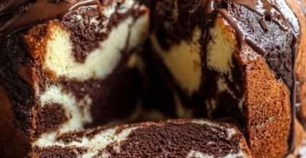 Gâteau marbré à la ricotta et au double chocolat nappé de glaçage au chocolat, décoré de copeaux de chocolat noir, présenté sur une assiette avec une texture moelleuse et un marbrage visible à la découpe.