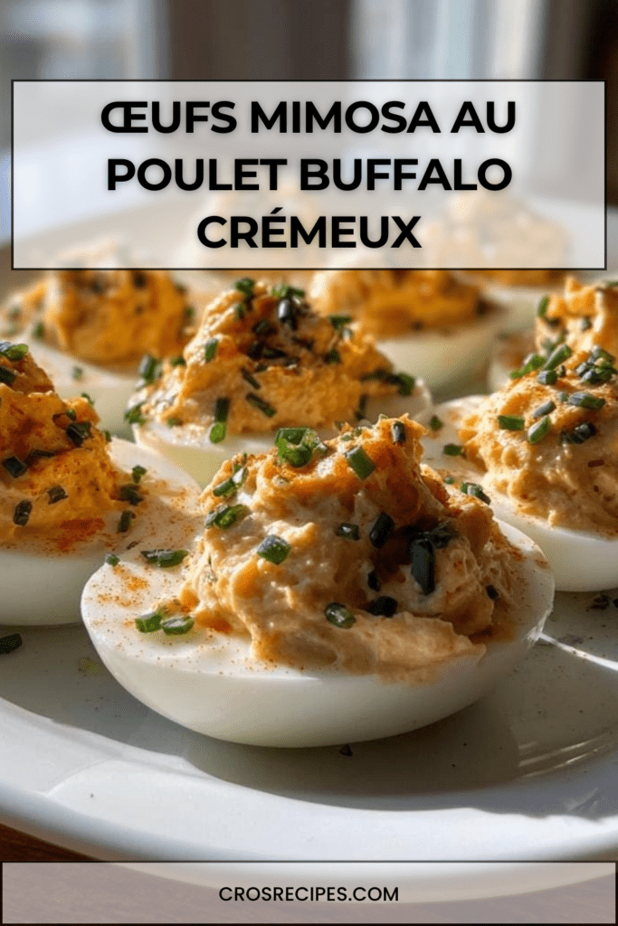 Œufs mimosa garnis de poulet Buffalo crémeux, décorés de paprika et de ciboulette fraîche, servis sur un plateau pour un apéritif.