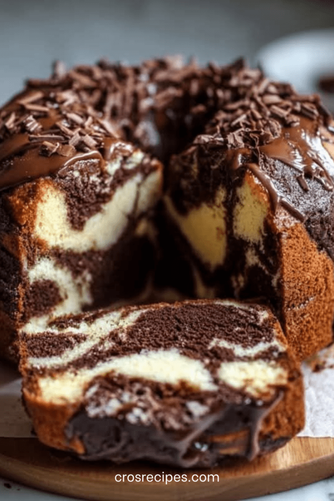 Gâteau marbré à la ricotta et au double chocolat nappé de glaçage au chocolat, décoré de copeaux de chocolat noir, présenté sur une assiette avec une texture moelleuse et un marbrage visible à la découpe.