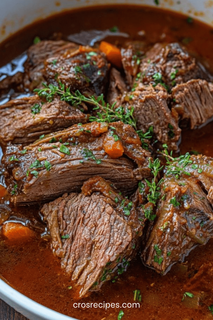 Bœuf braisé au vin rouge servi dans une cocotte, avec morceaux de viande fondants, carottes, sauce sombre brillante, persil frais et thym en finition.