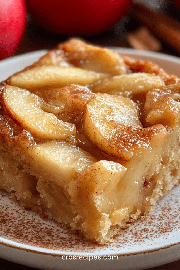 Gâteau fondant aux pommes et doré, avec tranches de pommes caramélisées sur le dessus et légère touche de cannelle
