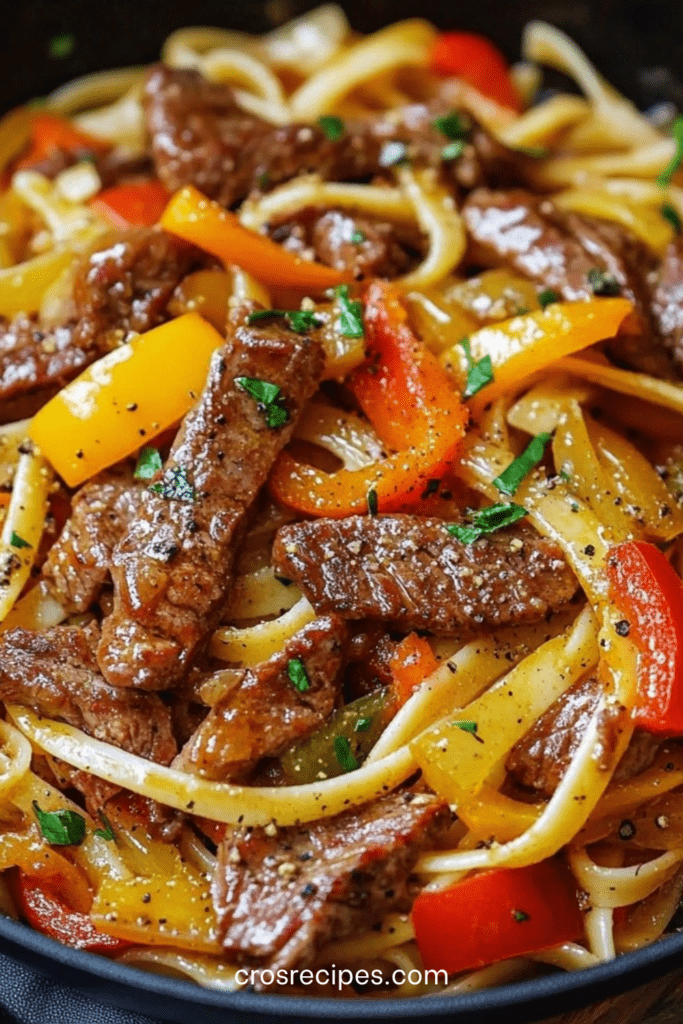 Assiette de nouilles sautées au bœuf avec poivrons rouges, jaunes et verts, oignon émincé et herbes fraîches, servie bien chaude dans un style asiatique gourmand.