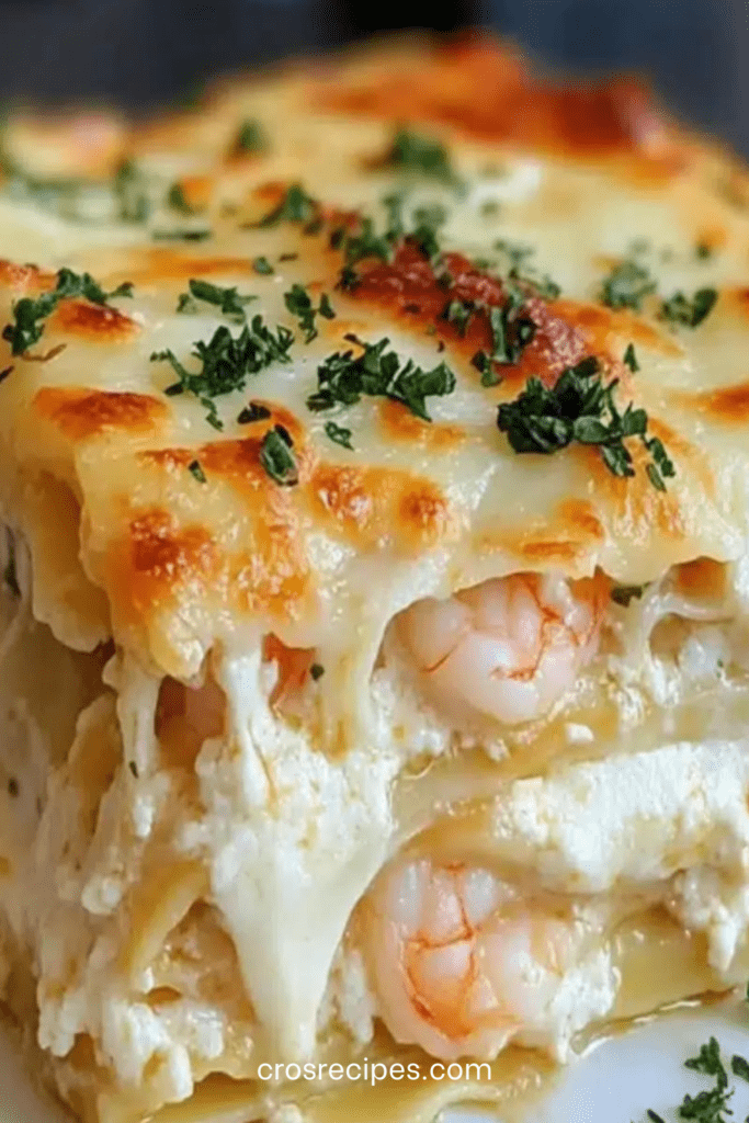 Plat de lasagnes crémeuses aux crevettes avec couches de pâtes, ricotta et fromage gratiné doré au four, garni de persil frais.