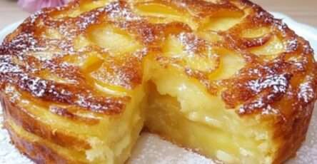 Tarte aux pommes super crémeuse, dorée et légèrement caramélisée, garnie de fines tranches de pommes, saupoudrée de sucre glace sur assiette.