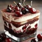 Verrines de tiramisu Forêt-Noire avec couches de biscuits imbibés, crème mascarpone, cerises, cacao et copeaux de chocolat noir.