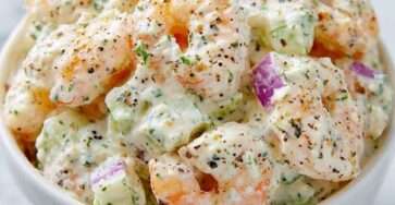 Bol de salade de crevettes façon deli new-yorkais avec mayonnaise, céleri croquant, oignon rouge et herbes fraîches, servi sur pain grillé.