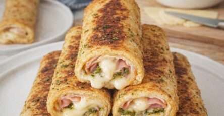 Pain perdu salé jambon-fromage au pesto et mozzarella, doré à la poêle, garni de jambon blanc, mozzarella fondante et tomates confites, servi chaud avec salade verte.