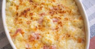 Gratin de chou-fleur au jambon maigre et mozzarella légère doré au four, servi dans un plat gratiné avec sauce crémeuse légère et herbes fraîches.