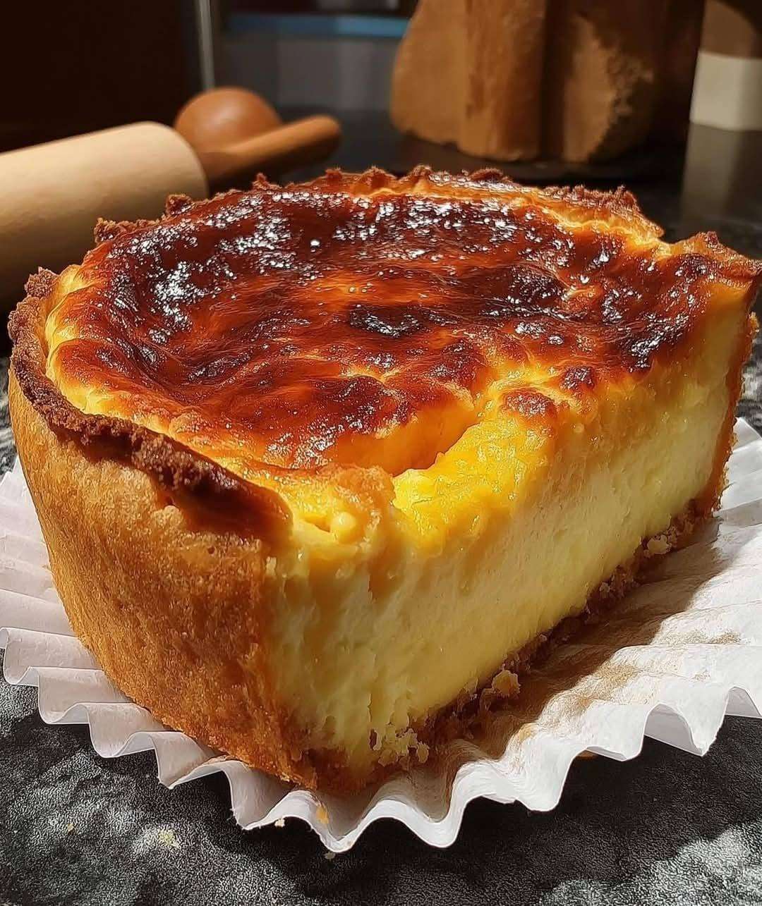 Flan boulanger maison à la vanille sur pâte croustillante, à la surface dorée et légèrement caramélisée, présenté en parts sur une assiette.