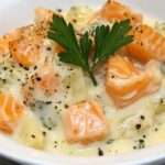 Blanquette de saumon crémeuse avec poireaux et carottes servie dans une assiette avec sauce onctueuse et persil frais.