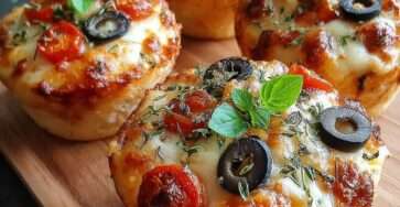 Mini pizzas maison garnies de mozzarella fondante, tomates cerises coupées en deux, olives noires, basilic frais et herbes, servies chaudes sur une assiette.`