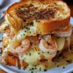 Croque-monsieur aux crevettes avec pain doré croustillant, fromage fondu filant et garniture crémeuse aux crevettes et persil frais.