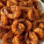 Assiette de crevettes croustillantes panées au parmesan et à l’ail, dorées et servies chaudes avec persil frais et quartier de citron