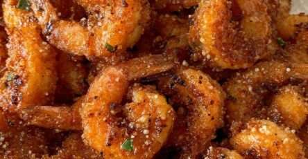 Assiette de crevettes croustillantes panées au parmesan et à l’ail, dorées et servies chaudes avec persil frais et quartier de citron