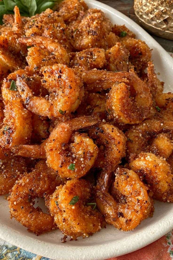 Assiette de crevettes croustillantes panées au parmesan et à l’ail, dorées et servies chaudes avec persil frais et quartier de citron