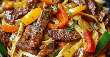 Assiette de nouilles sautées au bœuf avec poivrons rouges, jaunes et verts, oignon émincé et herbes fraîches, servie bien chaude dans un style asiatique gourmand.
