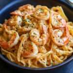 Assiette de pâtes crémeuses aux crevettes et chair de crabe, nappées d’une sauce cajun onctueuse avec persil frais et parmesan.