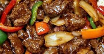 Assiette de bœuf aux poivrons à la chinoise avec lamelles de bœuf sautées, poivrons colorés, oignons fondants, sauce brillante et riz blanc servi chaud.