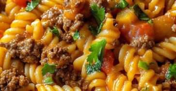 Assiette de fusilli au bœuf haché et à la tomate, nappés d’une sauce rouge brillante, garnis de persil frais haché et servis bien chauds.